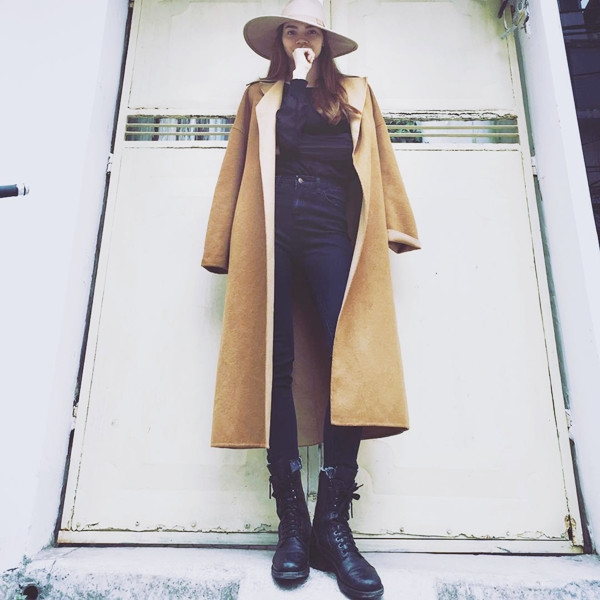 Hồ Ngọc Hà gây ấn tượng mạnh khi diện bộ cánh tuyền đen cùng bốt quân đội. Cô chọn áo khoác dáng dài (trench coat) gam màu vàng nâu và mũ vành tròn phối kèm ăn ý, giúp trang phục thêm nổi bật. 