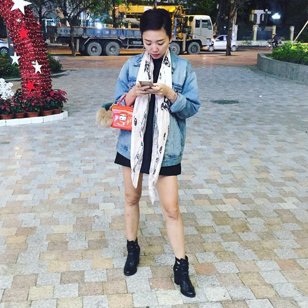 Tóc Tiên biến tấu mới lạ công thức mix đầm đen và áo khoác denim bụi phủi bằng chiếc khăn cổ quàng hờ và túi xách mini đính móc lông thời thượng.