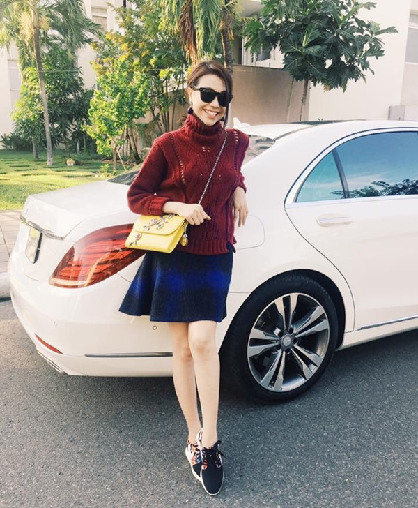 Trà Ngọc Hằng 'thắp sáng' street style ngày đông với áo len cổ lọ màu đỏ rượu và chân váy ngắn. Chiếc túi mang sắc vàng tươi sáng điểm trang cho người đẹp nét năng động, tràn đầy sức sống.