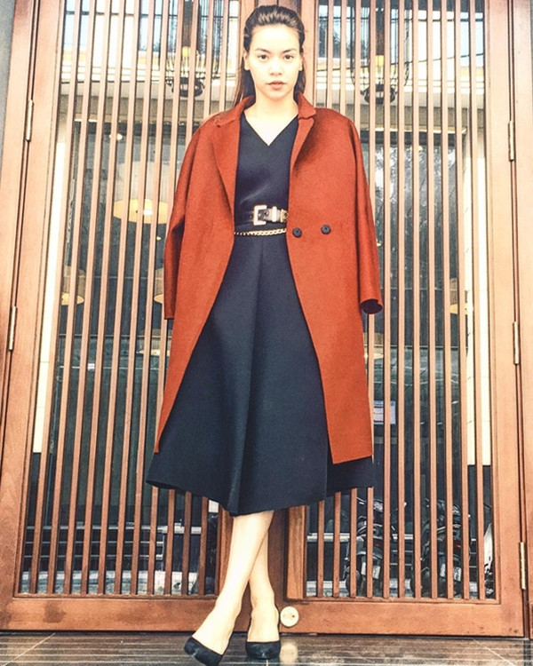 'Nữ hoàng giải trí' mê mẩn cách khoác hờ áo trench coat tông màu nổi bật cùng đầm tối màu kiểu dáng đơn giản. Cô không quên tạo điểm nhấn eo bằng thắt lưng có các chi tiết kim loại vàng ánh kim.