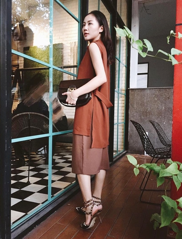 Văn Mai Hương tận hưởng tiết trời Sài Gòn ấm áp với bộ đầm gam màu nâu trầm nền nã. Nữ ca sỹ phối cùng sandals cao gót nạm đinh của Valentino và túi da đồng màu.