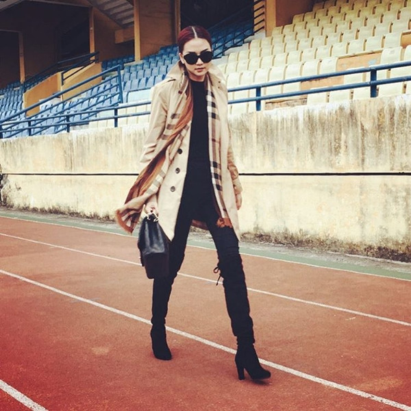 Diện áo khoác trench của nhà mốt Burberry trứ danh, Thiều Bảo Trang 'bắt cặp' trang phục cùng khăn quàng kẻ ô vuông tiệp màu camel, mang đậm cảm hứng Anh quốc.