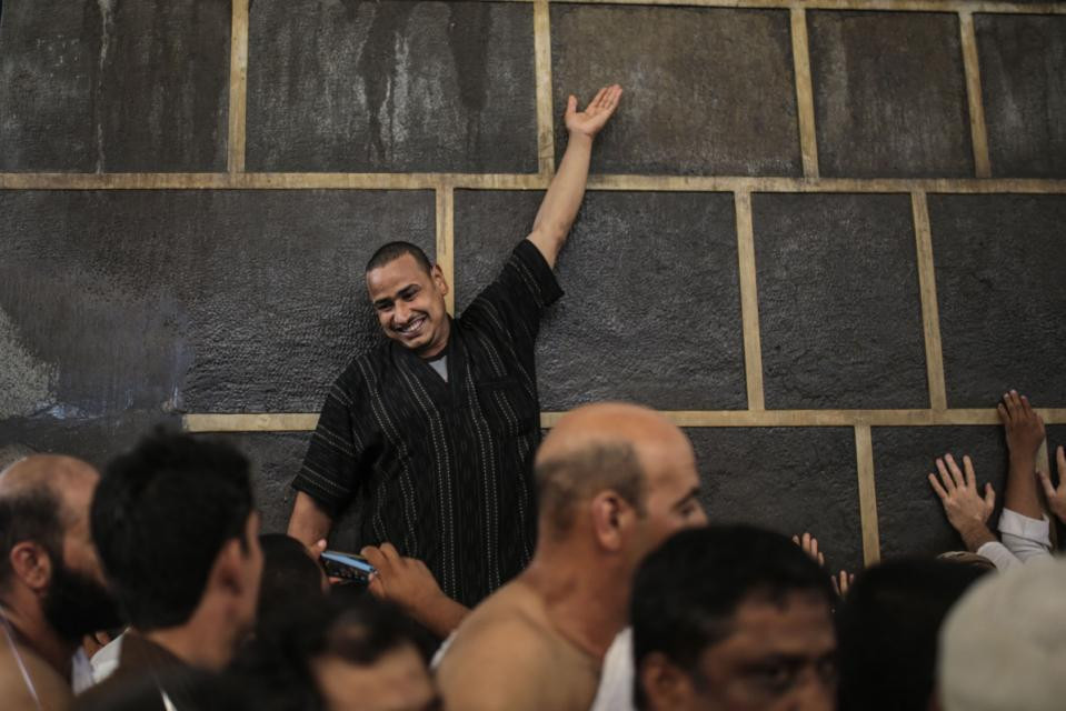 Một người hành hương cười tươi đứng bên cạnh đền Kaaba. (Nguồn: AP)