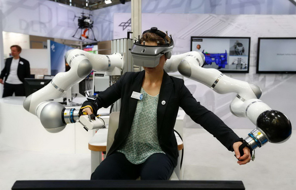 Một người phụ nữ sử dụng HUG (Haptic User Geraet) tại 6 Hội chợ Thương mại Tự động hóa và cơ điện tử ở Munich. Thiết bị này gồm hai cánh tay robot. (Nguồn: Reuters)