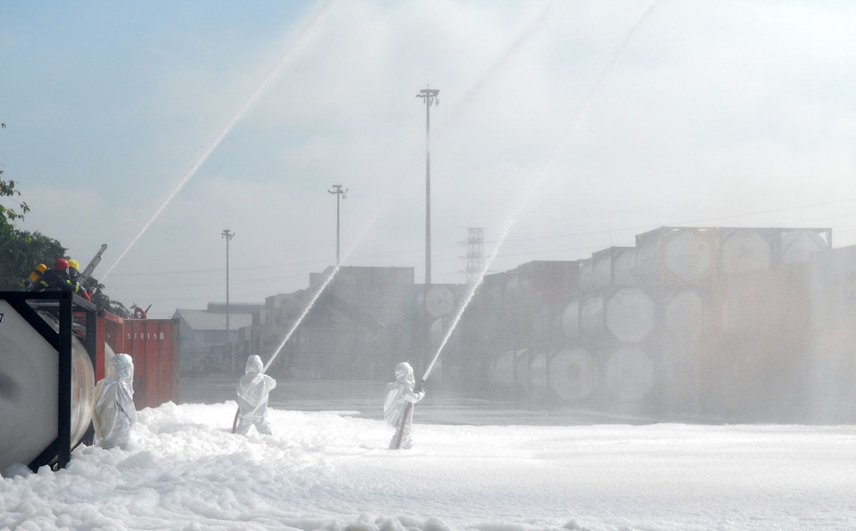 Các lực lượng phòng cháy chữa cháy thực hành phun hóa chất ứng phó sự cố rò rỉ. (Ảnh: Mạnh Linh/TTXVN)