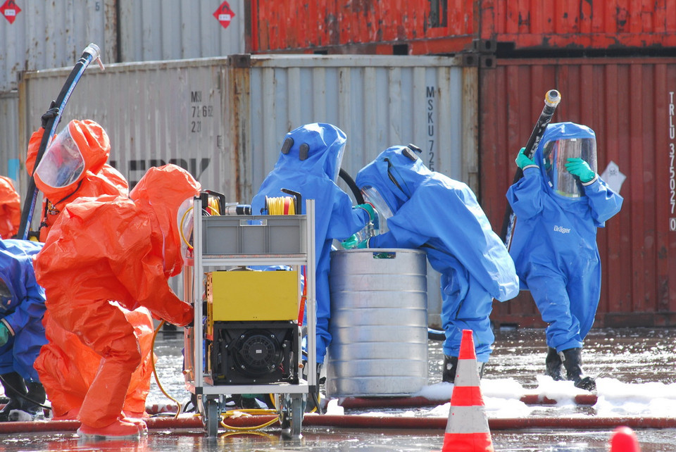  Lực lượng tiến hành thu gom hóa chất. (Ảnh: Mạnh Linh/TTXVN)