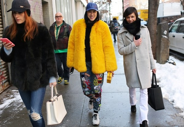 Tổng biên tập Tạp chí Lucky- Eva Chen (giữa) 'chơi trội' với áo choàng lông gam màu vàng cực nổi. Cô diện quần jeans cá tính của DKNY và giày sneakers của Opening Ceremony.