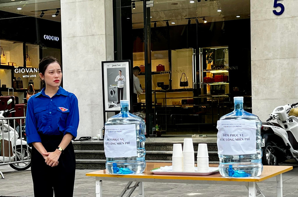 Thanh niên Thông tấn xã Việt Nam phục vụ nước uống miễn phí tại khu vực số 5 Lý Thường Kiệt. (Ảnh: Nam Khánh/TTXVN)