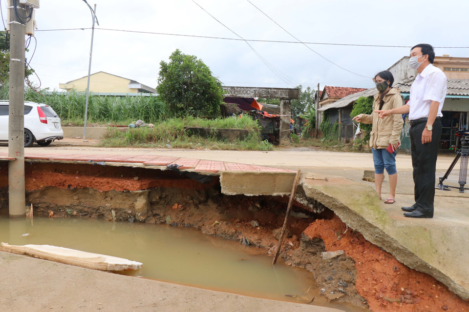Mưa lũ làm sạt lở vỉa hè và mái taluy đường ĐH 01 tại thôn Tân Phước. (Ảnh: Sỹ Thắng/TTXVN)
