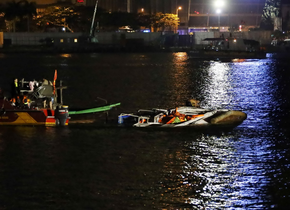 Tàu du lịch bị chìm (bên phải) nổi lên một phần trên sông Hàn. (Ảnh: Trần Lê Lâm/TTXVN)