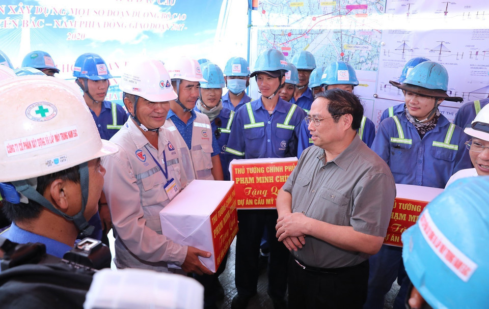 Thủ tướng Phạm Minh Chính tặng quà động viên công nhân xây dựng cầu Mỹ Thuận 2. (Ảnh: Dương Giang/TTXVN)