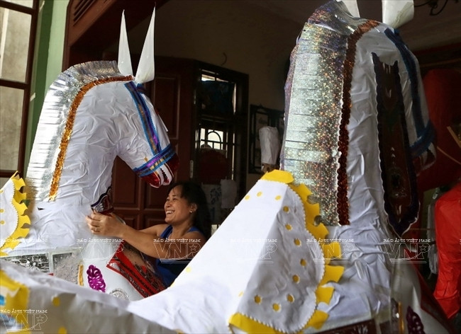 Chị Đinh Thị Thúy đang hoàn thiện những chi tiết hoa văn cuối cùng của cặp ngựa mã cao gần hai mét để ban giao cho Ban quản lý di tích Đền Hùng (Phú Thọ). (Ảnh: Thông Thiện/Báo ảnh Việt Nam) 