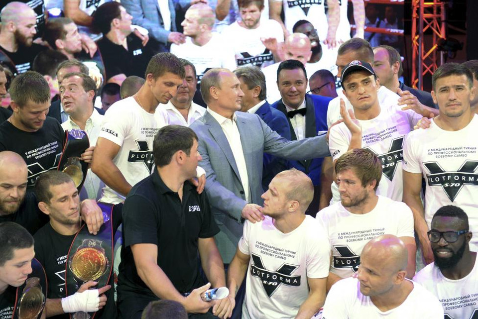 Tổng thống Nga Vladimir Putin (Giữa) và Thủ tướng Nga Dmitry Medvedev (Đứng thứ 2, hàng 2 bên trái) chụp ảnh cùng các vận động viện tham gia giải đấu vật được tổ chức tại Sochi. Bức ảnh được chụp vào ngày 8/10/2014. (Nguồn: REUTERS)