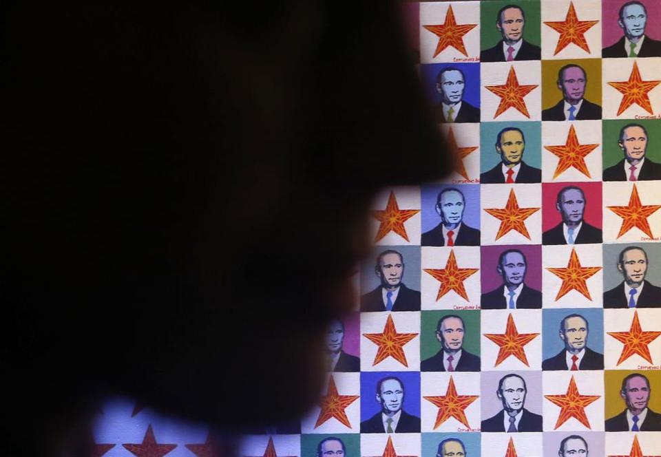 Khuôn mặt một người phụ nữ in bóng trên một tấm áp phích giới thiệu chương trình thời trang "Tổ quốc", được tổ chức vào ngày kỷ niệm sinh nhật lần thứ 62 của Tổng thống Nga Vladimir Putin, tại St Petersburg vào ngày 07 Tháng 10 2014. (Nguồn: REUTERS)