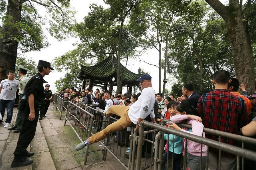 Một du khách khác nhảy qua hàng rào để không phải xếp hàng. (Nguồn: QQ News)