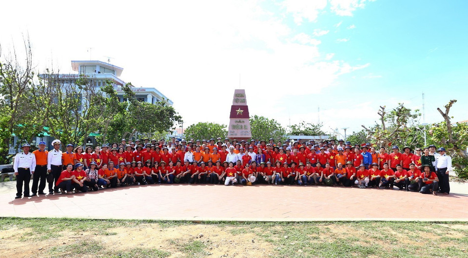 Đại biểu đoàn công tác số 5 chụp ảnh bên cột mốc chủ quyền của đảo Trường Sa lớn. (Ảnh: Minh Quyết/TTXVN)