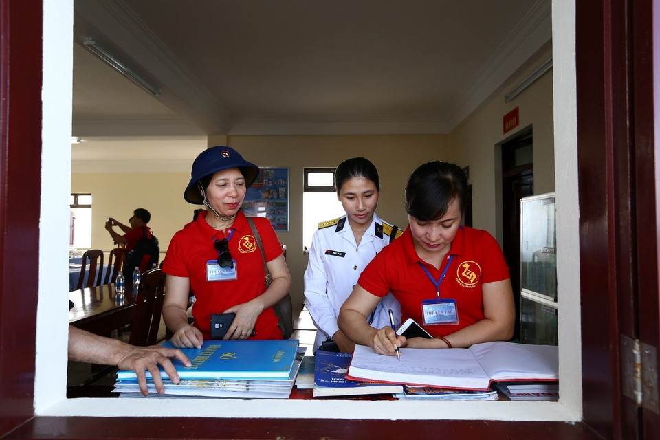 Đại biểu ghi lưu bút tại đảo Tiên Nữ. (Ảnh: Minh Quyết/TTXVN)