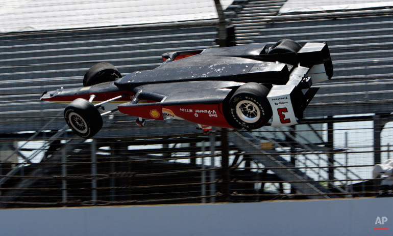 Xe đua của vận động viên Brazil Helio Castroneves bay lên trời sau khi đâm vào tường ở vòng đua đầu tiên ở sân đua Indianapolis. (Nguồn: AP)