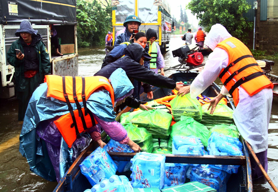 Tập kết nhu yếu phẩm, nước sạch lên thuyền để trao đến người dân các vùng thấp trũng còn bị ngập nước của huyện Lệ Thủy (Quảng Bình). (Ảnh: Tá Chuyên/TTXVN)