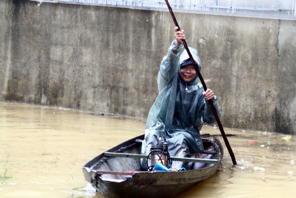 Người dân dùng thuyền đi lại tại các vùng thấp trũng, nước chưa rút hết tại huyện Lệ Thủy (tỉnh Quảng Bình). (Ảnh: Tá Chuyên/TTXVN)