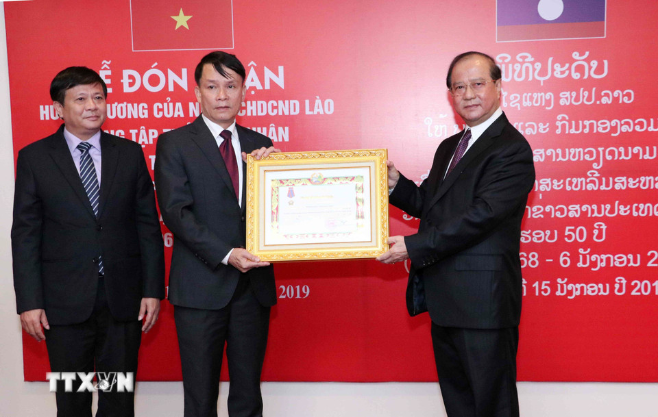 Bộ trưởng Bộ Thông tin, Văn hóa và Du lịch Lào Bosengkham Vongdara trao tặng Huân chương Tự do Isala hạng Nhì cho TTXVN. (Ảnh: Văn Điệp/TTXVN)