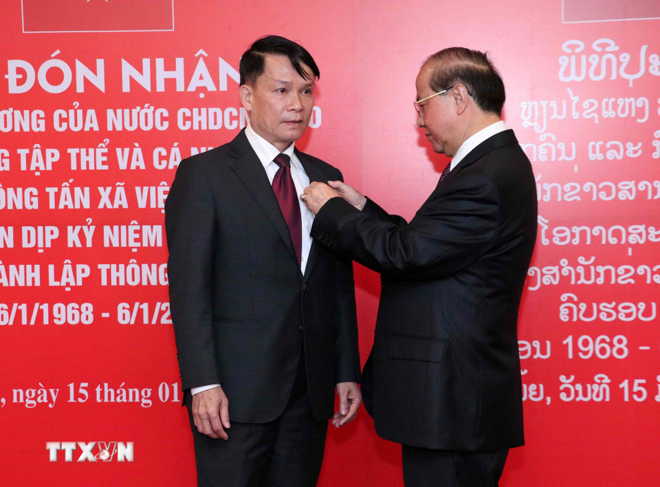 Bộ trưởng Bộ Thông tin, Văn hóa và Du lịch Lào Bosengkham Vongdara gắn Huân chương Tự do Isala hạng Nhì cho đồng chí Nguyễn Đức Lợi, Ủy viên Trung ương Đảng, Bí thư Đảng ủy, Tổng Giám đốc TTXVN. (Ảnh: Văn Điệp/TTXVN)