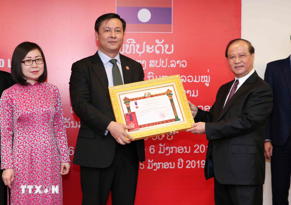 Bộ trưởng Bộ Thông tin, Văn hóa và Du lịch Lào Bosengkham Vongdara trao tặng Huân chương Lao động hạng Ba của Lào cho Ban Thư ký biên tập và Quan hệ đối ngoại. (Ảnh: Văn Điệp/TTXVN)