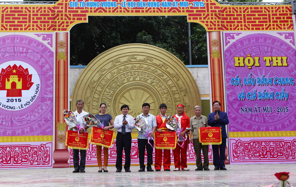 Ban tổ chức trao cờ lưu niệm cho các đoàn của các tỉnh tham dự Hội thi gói bánh chưng. (Ảnh: Quý Trung/TTXVN) 