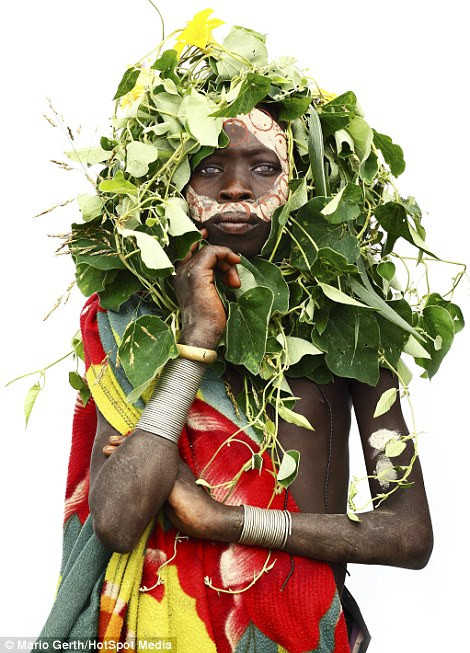 Các em bé của bộ lạc Surma từ Ethiopia đội chiếc mũ và mặt nạ làm từ cây cỏ và đất sét trắng. (Nguồn: Dailymail.co.uk)