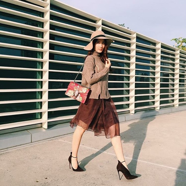 Diễm My 9X hút hồn với phong cách tiểu thư đài các, kiêu kỳ. Nữ diễn viên tài năng phối áo len cổ lọ và chân váy voan nữ tính, điệu đà. Mũ fedora và giày cao gót da lộn cũng được người đẹp mix rất ăn ý. Và điểm nhấn đắt giá cho tổng thể trang phục chính là túi xách Gucci in hoa lãng mạn.