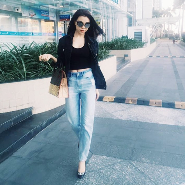 Trà Ngọc Hằng khoe eo thon trên phố với áo lửng và quần jeans. Sơmi denim cũng được người đẹp biến tấu thành áo khoác nhẹ nhàng cho tổng thể trang phục.