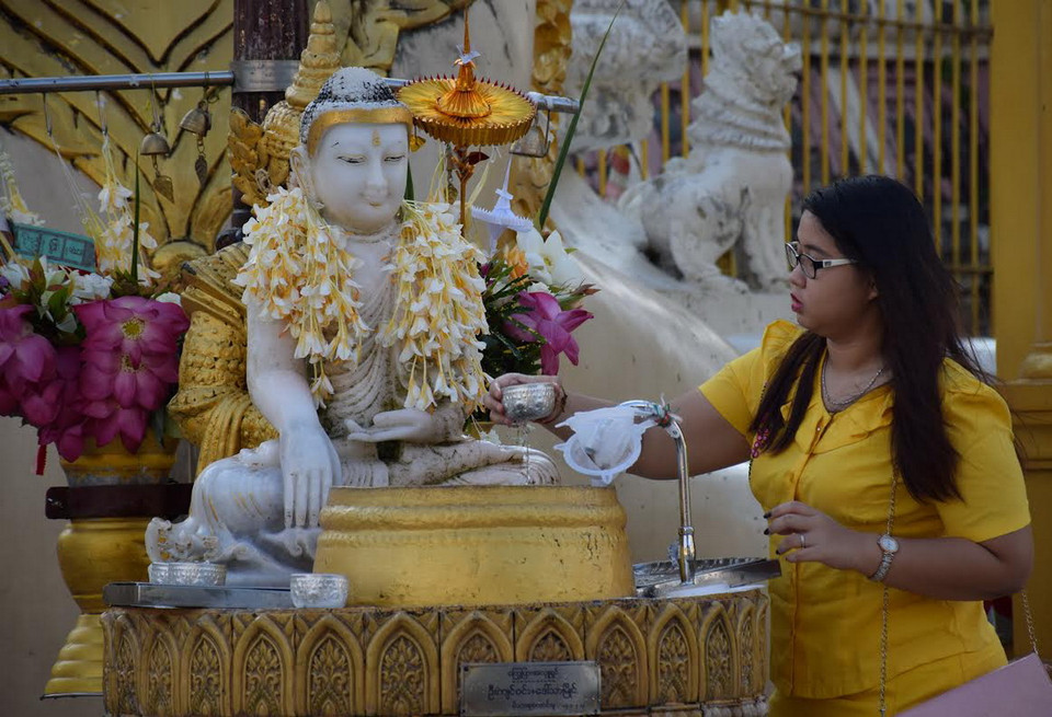Tưới nước tắm cho tượng Phật. (Ảnh: Sơn Nam/Vietnam+)
