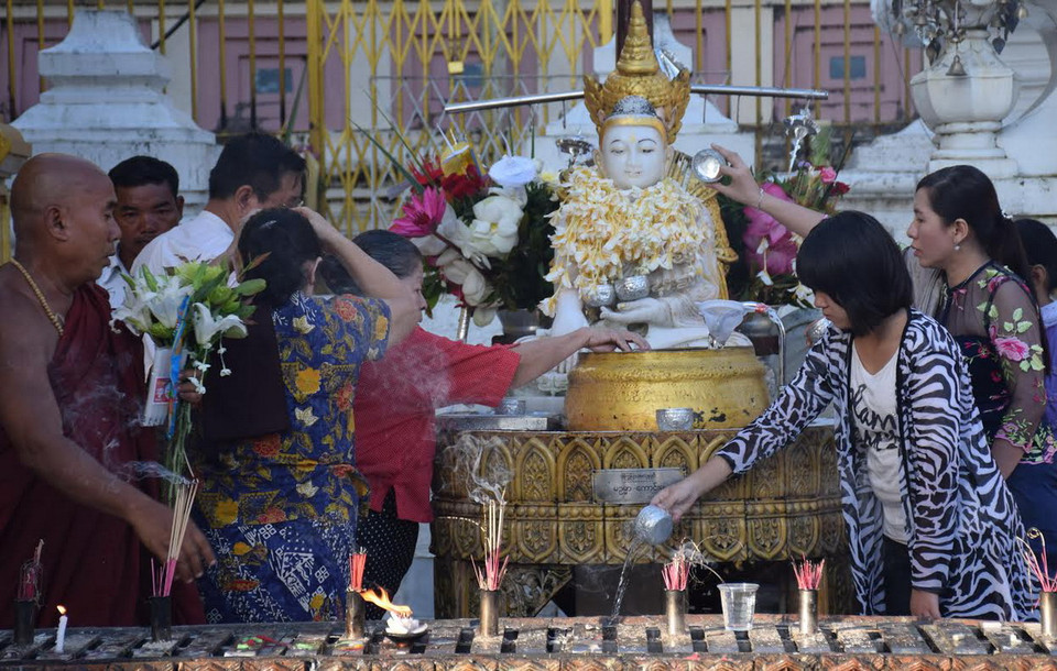 Tưới nước tắm cho tượng Phật. (Ảnh: Sơn Nam/Vietnam+)