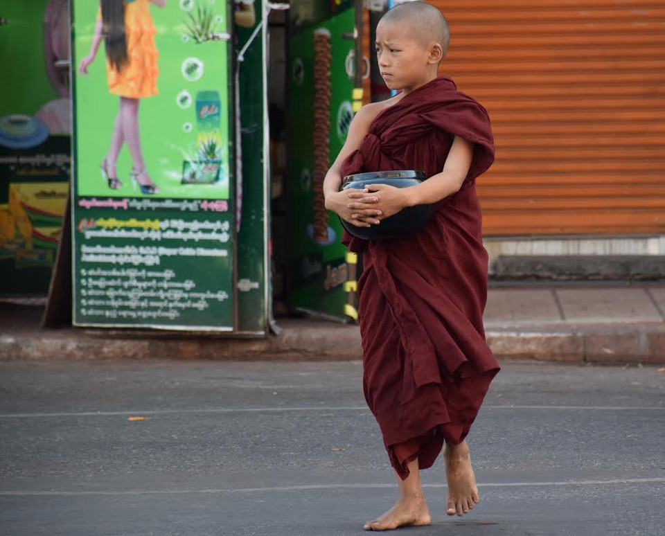 Một chú tiểu đi khất thực trên phố. (Ảnh: Sơn Nam/Vietnam+)