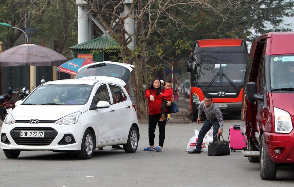 Một gia đình lên chuyến xe cuối cùng về quê đón Tết. (Ảnh: Quốc Khánh/TTXVN)