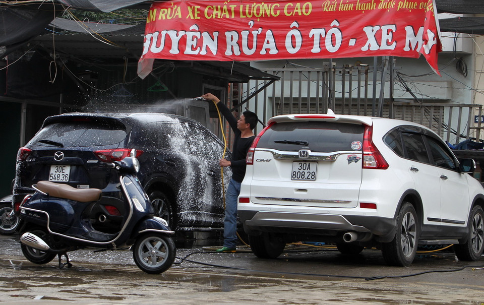Dịch vụ rửa xe đông khách hơn thường ngày. (Ảnh: Quốc Khánh/TTXVN)