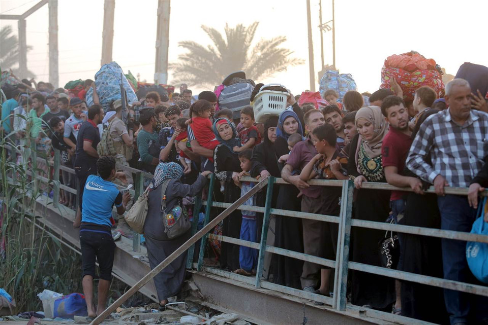 Những người tị nạn vượt qua cây cầu ở ngoại ô Baghdad. (Nguồn: NBCNews)