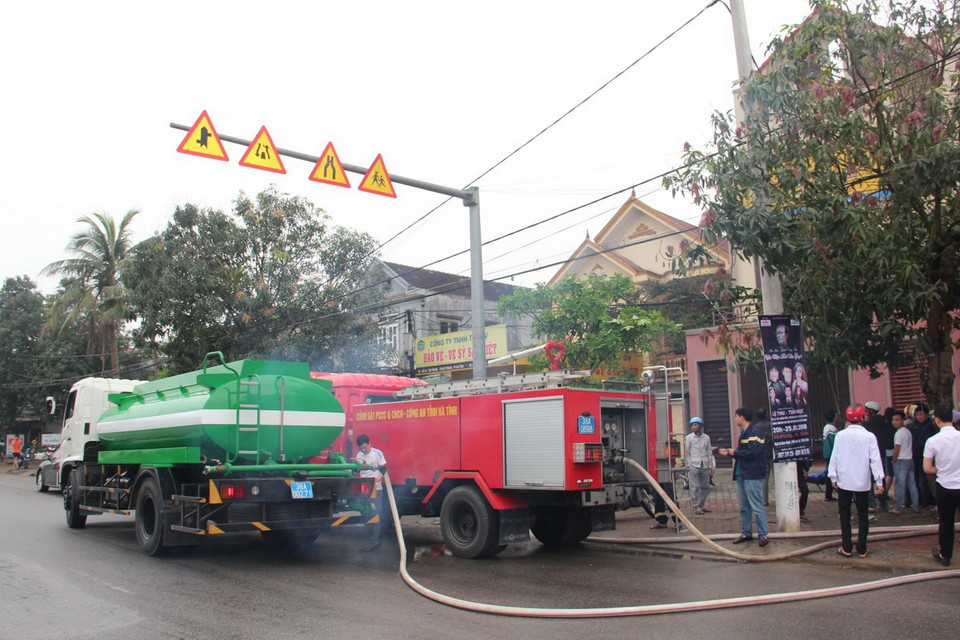 Lực lượng chữa cháy vẫn đang tiếp tục huy động nhiều xe bồn, xe chữa cháy đến phun nước để dập tắt đám cháy. (Ảnh: Hoàng Ngà/TTXVN)