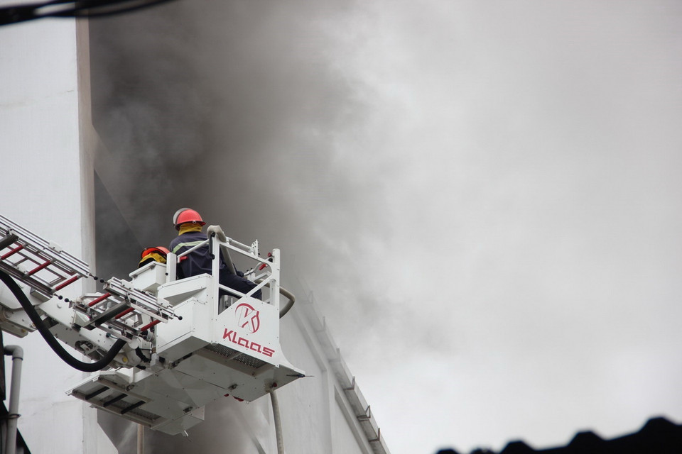 Lực lượng chữa cháy dùng xe thang tiếp cận hiện trường phun nước dập lửa. (Ảnh: Hoàng Ngà/TTXVN)