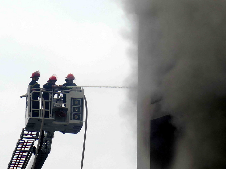 Cảnh sát phòng cháy chữa cháy nỗ lực chữa cháy. (Ảnh: Công Tường/TTXVN)