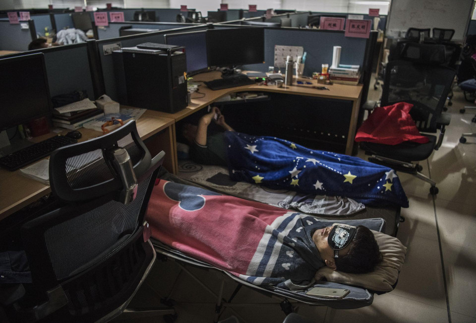 Các nhân viên ngủ trong phòng làm việc của họ ở khu nghiên cứu và phát triển sau bữa ăn trưa. (Nguồn: Getty Images)