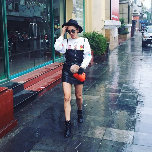 Sau cơn mưa đầu đông ở Hà Nội, Tóc Tiên xuống phố trong bộ cánh hút mắt. Cô mix áo nỉ họa tiết và đầm yếm da 'sang chảnh,' kết hợp phụ kiện là mũ vành tròn và bốt da làm bật vẻ năng động, mạnh mẽ.