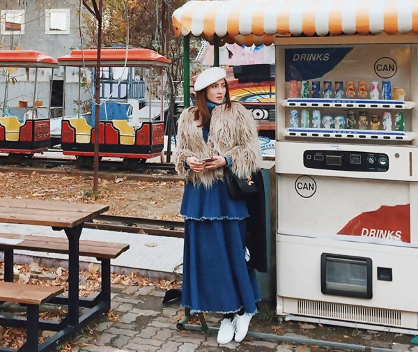 Là 'bạn đồng hành của Yến Trang trong hành trình tới Hàn Quốc, Yến Nhi cũng ghi dấu ấn với phong cách độc đáo. Cô diện đầm xanh xếp tầng cùng áo len cổ lọ, thu hút sự chú ý với áo khoác lông. Mũ nồi được đông đảo giới trẻ yêu thích tại Xứ củ sâm cũng là phụ kiện được Yến Nhi mix hiệu quả. 