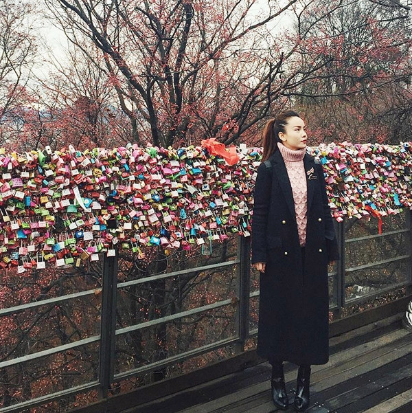 Trong chuyến du lịch tới 'xứ kim chi,' Yến Trang không quên ghi lại hình ảnh khám phá Seoul trong bộ trang phục ấm áp. Nữ ca sỹ phối áo len cổ tròn mang gam hồng phấn cùng áo khoác dạ dáng dài đậm phong cách Hàn Quốc, tận hưởng khoảnh khắc yên bình trên tháp Namsan.