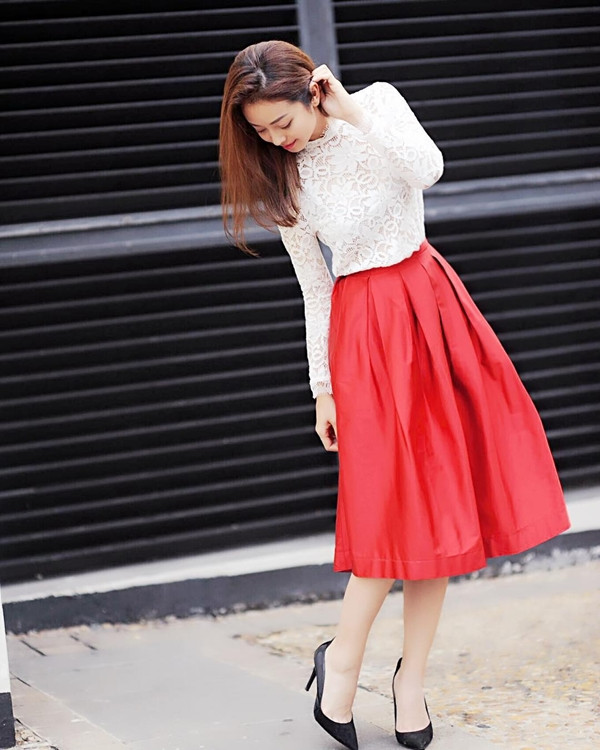 Jennifer Phạm 'thả dáng' trên phố trong trang phục nữ tính. Người đẹp kết hợp áo ren trắng và chân váy xòe màu đỏ điệu đà, tô điểm nét duyên dáng bằng đôi giày cao gót đen cổ điển.