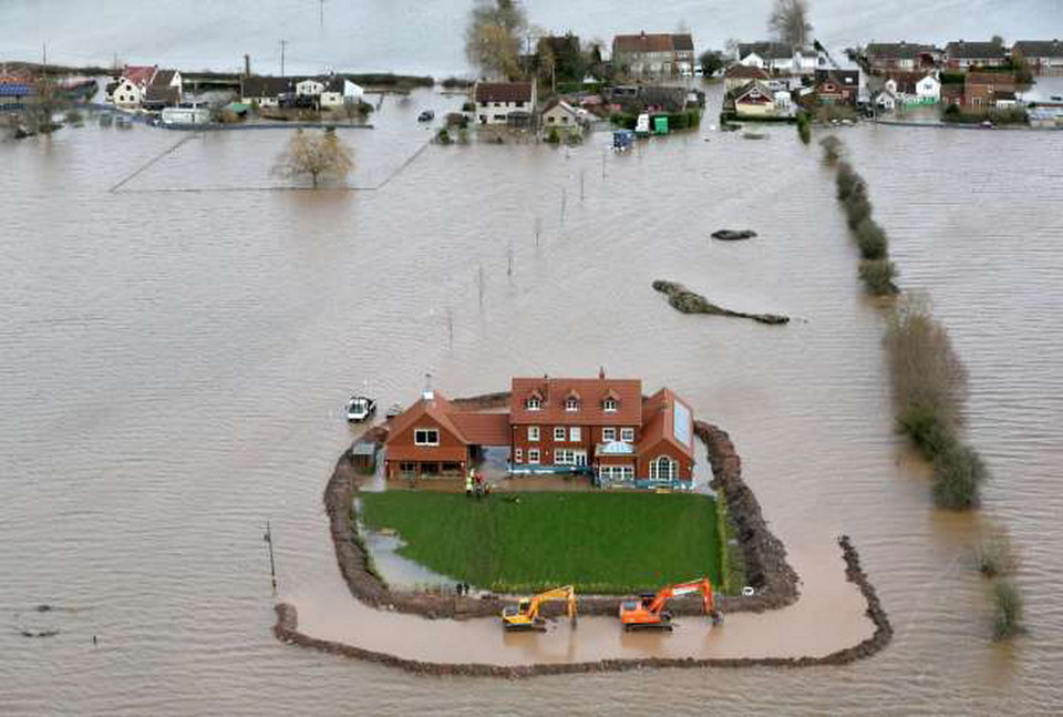 Công nhân xây hệ thống phòng chống ngập úng xung quanh một ngôi nhà ở làng Moorland. (Nguồn: Matt Cardy/Getty Images)