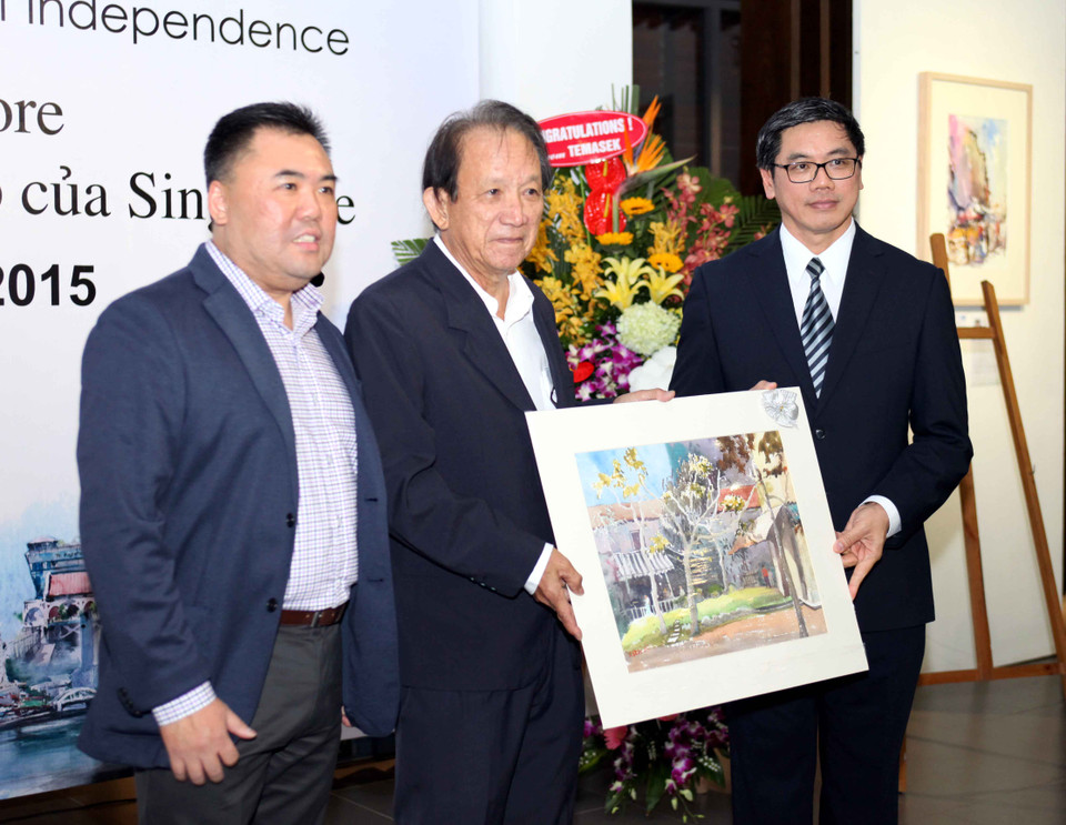 Ông Seah Kang Chui và ông Donald Tan – đại diện Hiệp hội màu nước Singapore tặng bức tranh cho Đại sứ Singapore Ng Teck Hean. (Ảnh: Doãn Đức/Vietnam+)