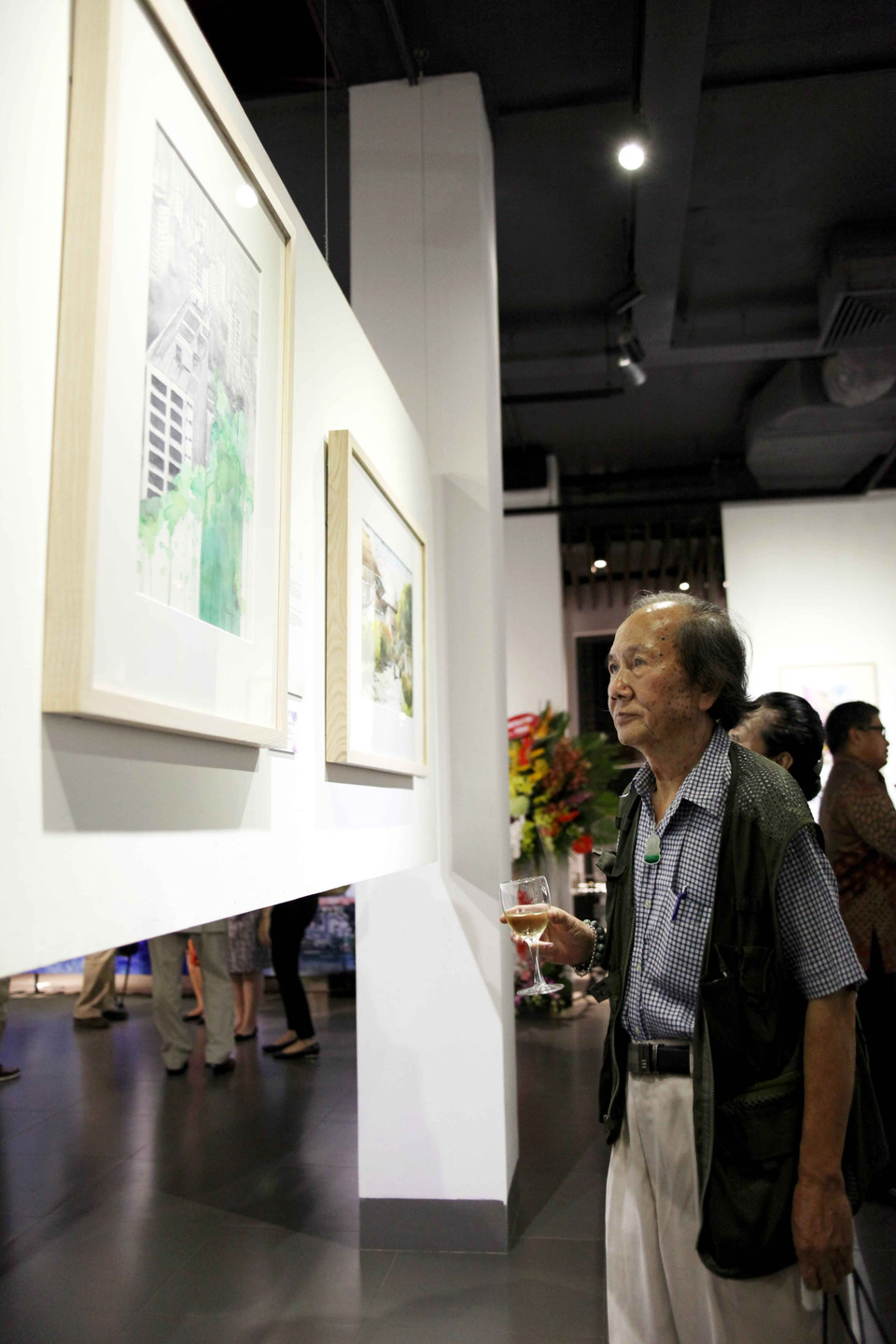 ‘Nhà rùa học’ Hà Đình Đức thưởng thức các tác phẩm trong triển lãm. (Ảnh: Doãn Đức/Vietnam+)