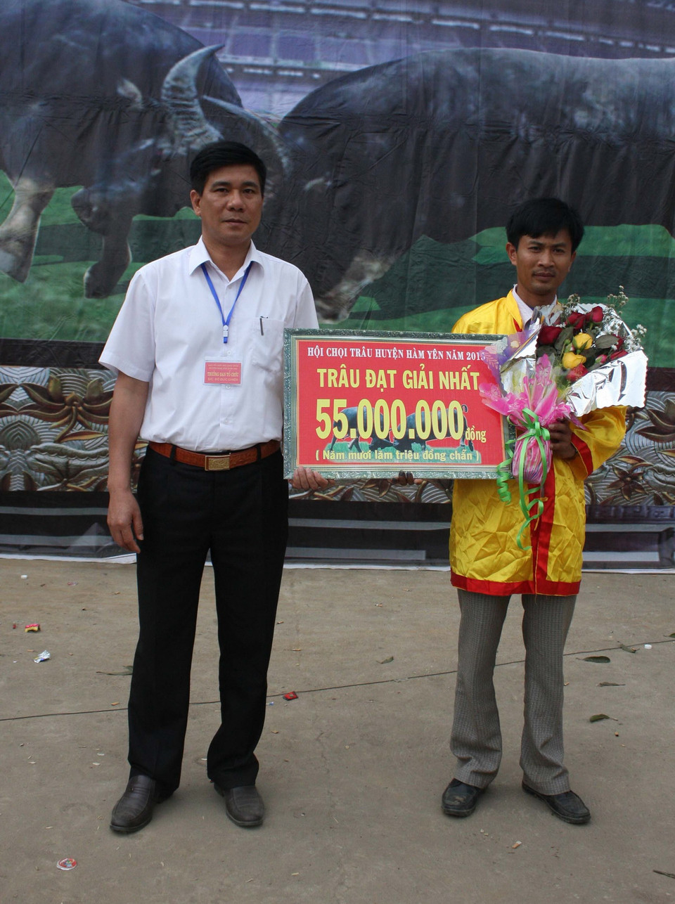 Ban tổ chức trao giải Nhất cho ông Nguyễn Đình Khoa (bên phải), xã Tân Thành, huyện Hàm Yên (Tuyên Quang) chủ trâu số 56- trâu vô địch lễ hội chọi trâu năm 2015. (Ảnh: Quang Đán/TTXVN) 