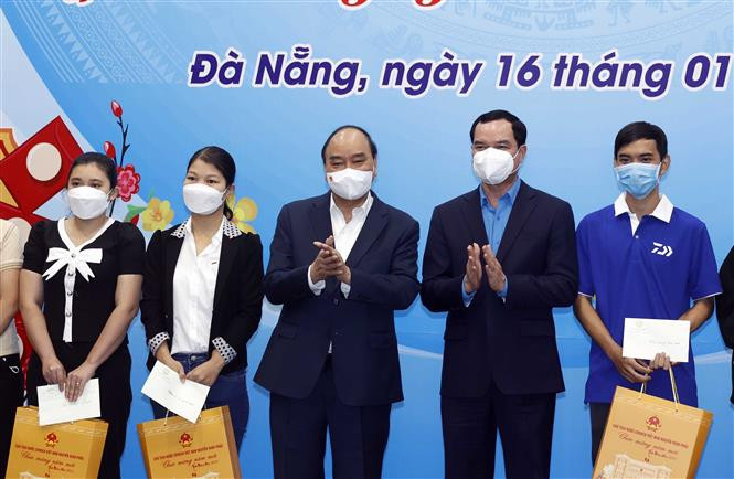 Chủ tịch nước Nguyễn Xuân Phúc trao quà Tết cho đại diện gia đình chính sách, gia đình có công với cách mạng, hộ nghèo, hộ khó khăn do bị ảnh hưởng nặng nề dịch bệnh COVID-19, công nhân, người lao động, người bị ảnh hưởng chất độc da cam/dioxin trên địa bàn thành phố Đà Nẵng. (Ảnh: Thống Nhất/TTXVN)